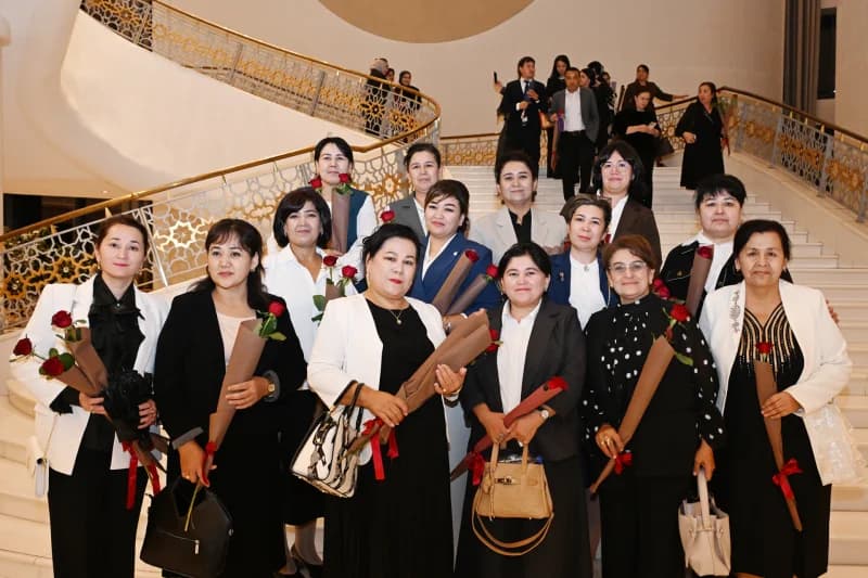 Group of women posing with roses on stairs