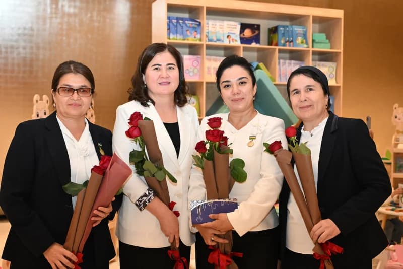 Group photo of four women holding bouquets of red roses