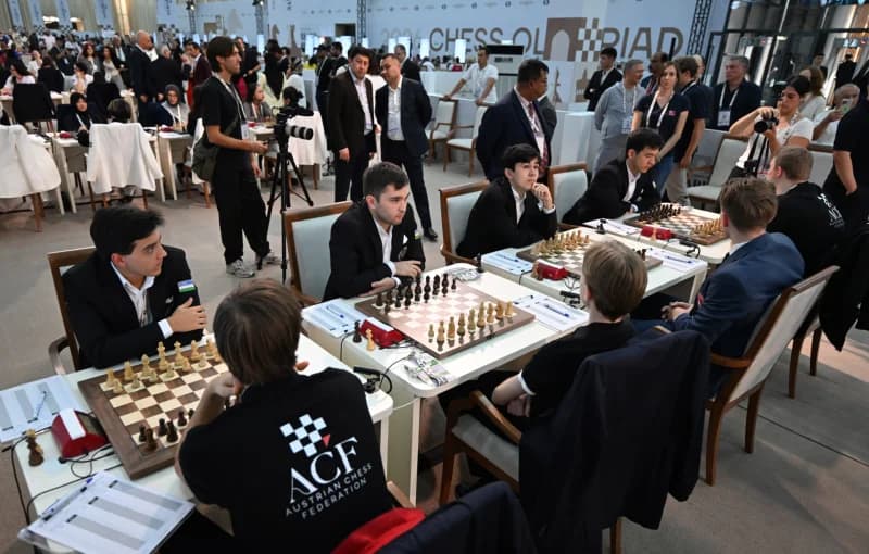 People playing chess at tables in a large hall