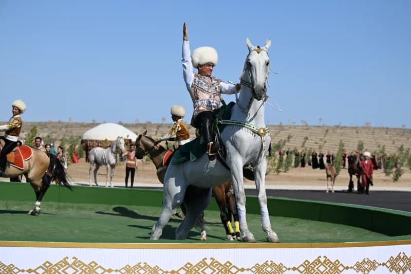 Person riding white horse and waving