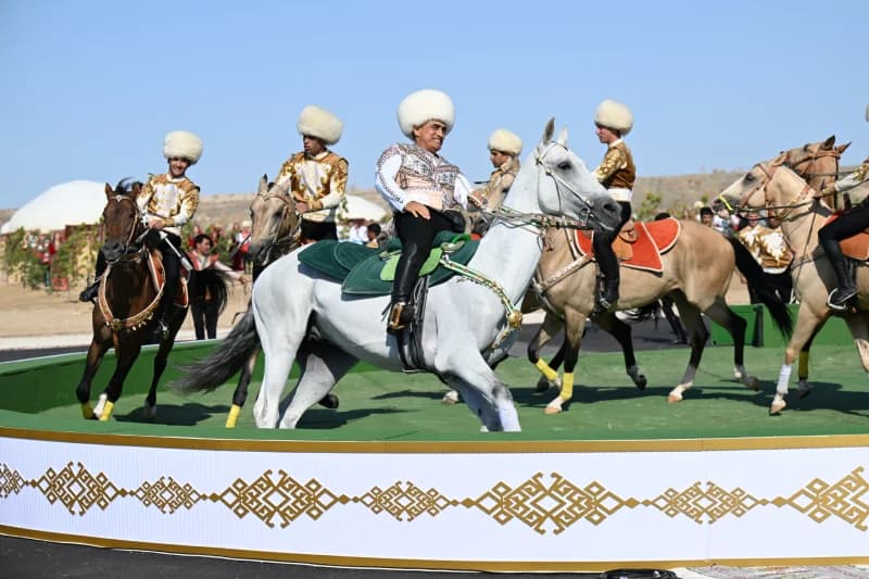 Men in traditional clothing riding horses in an outdoor arena