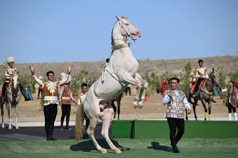 Performers with horses in traditional clothing outdoors
