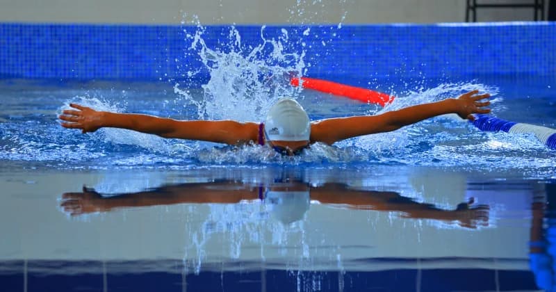 Athlete swimming butterfly stroke in indoor pool