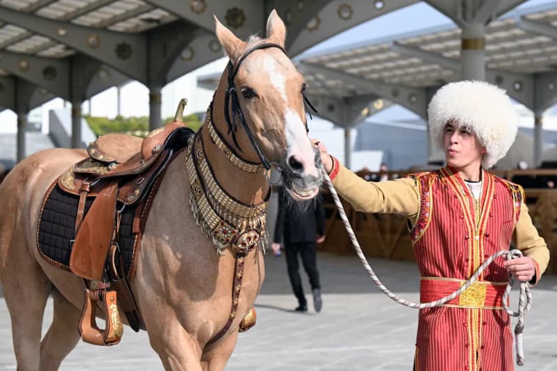 Person in national clothing leading a decorated horse
