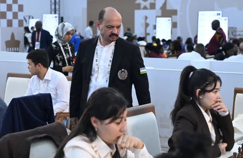 People participating in an indoor event with tables and chairs