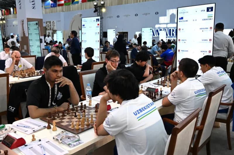 People playing chess at tables in a large hall