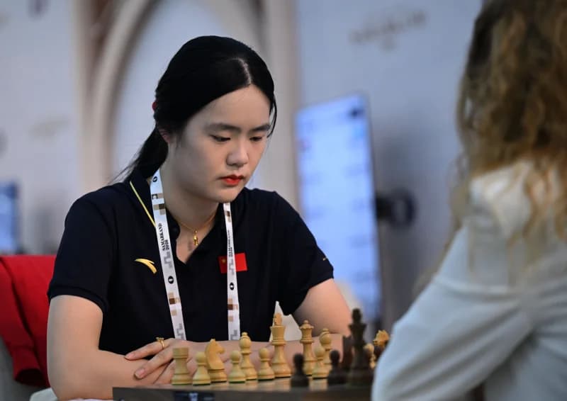 A woman playing a game of chess at a table