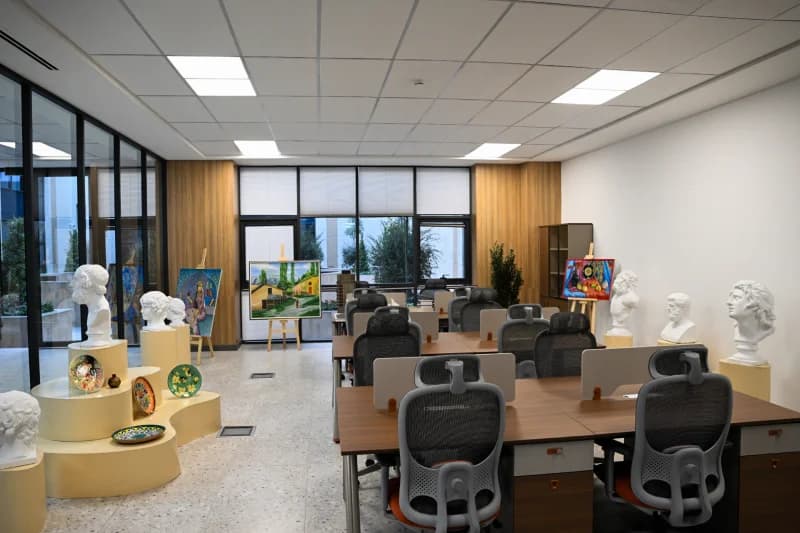 Bright interior room featuring desks and artistic displays