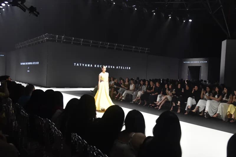 Model walking down runway during fashion show