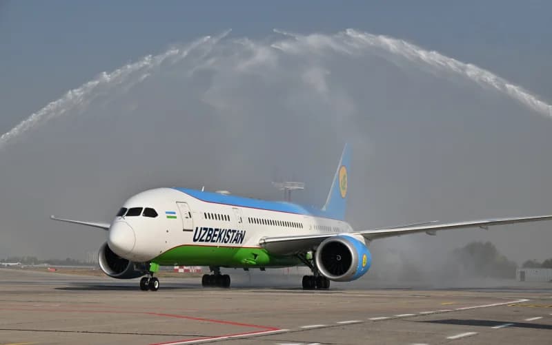 Самолет на асфальтовой дорожке аэропорта под водной аркой