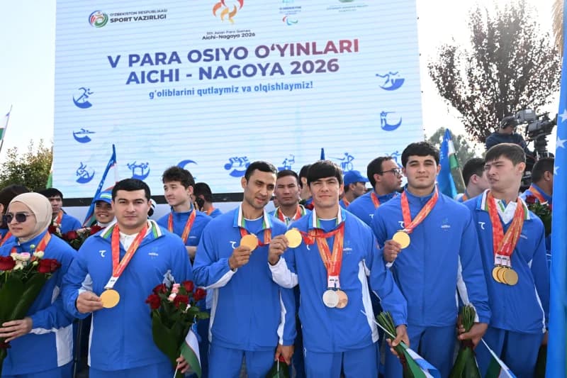 Group of athletes posing with medals and flowers
