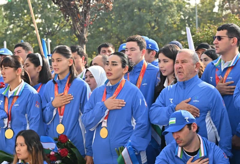 Group of people in sportswear placing hands on chests outdoors