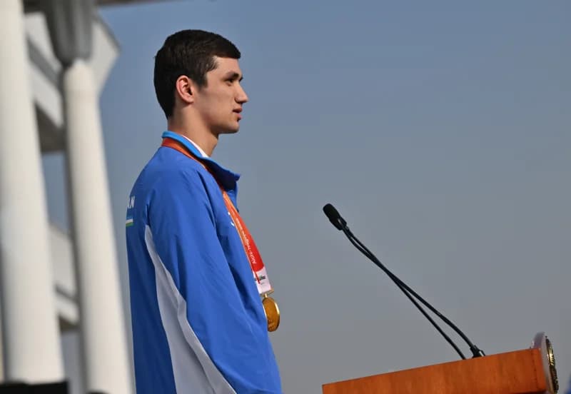 Athlete standing at a podium with a medal