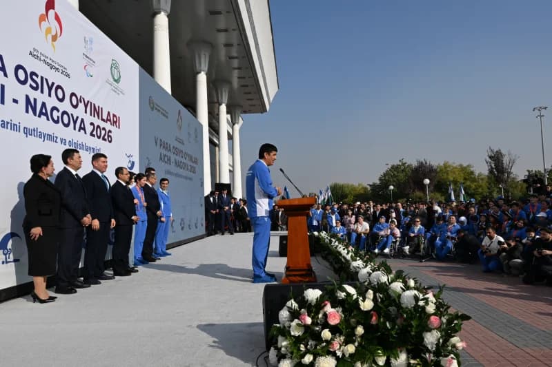 Person speaking at a podium during an outdoor gathering