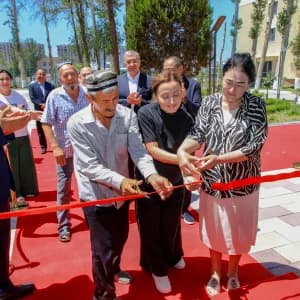 Люди режут красную ленту на улице