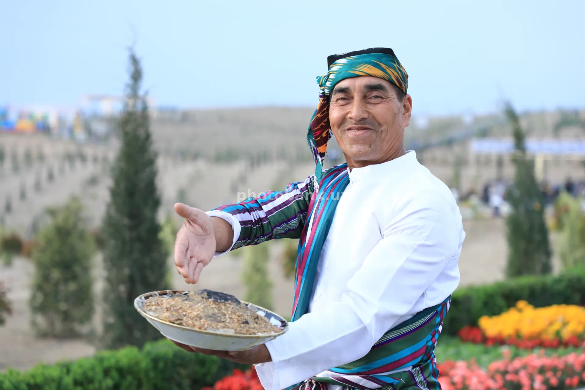 Taom taklif qilayotgan an’anaviy kiyimdagi erkak