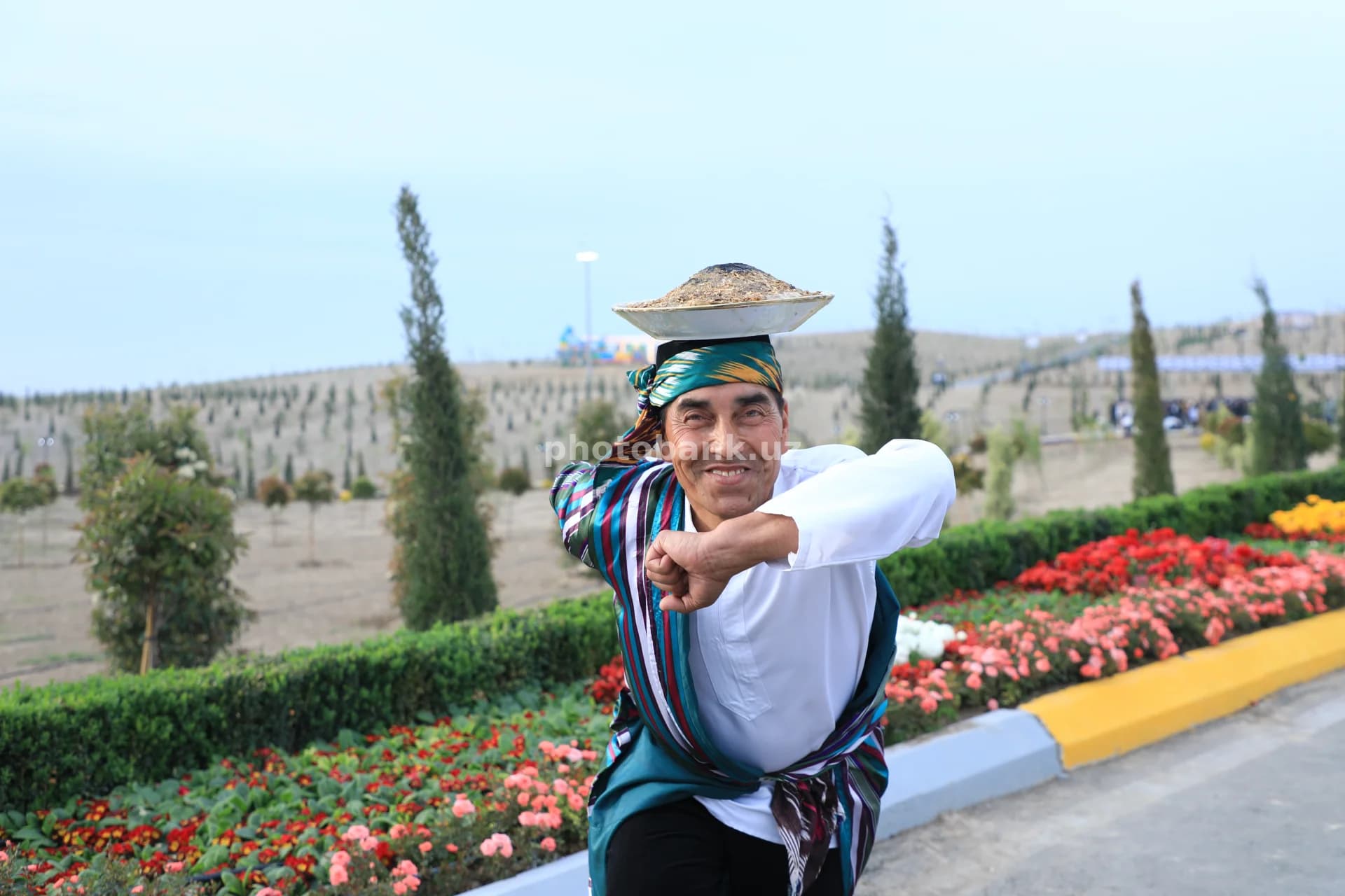 Erkak boshida muvozanat tarelkasini ushlab turibdi