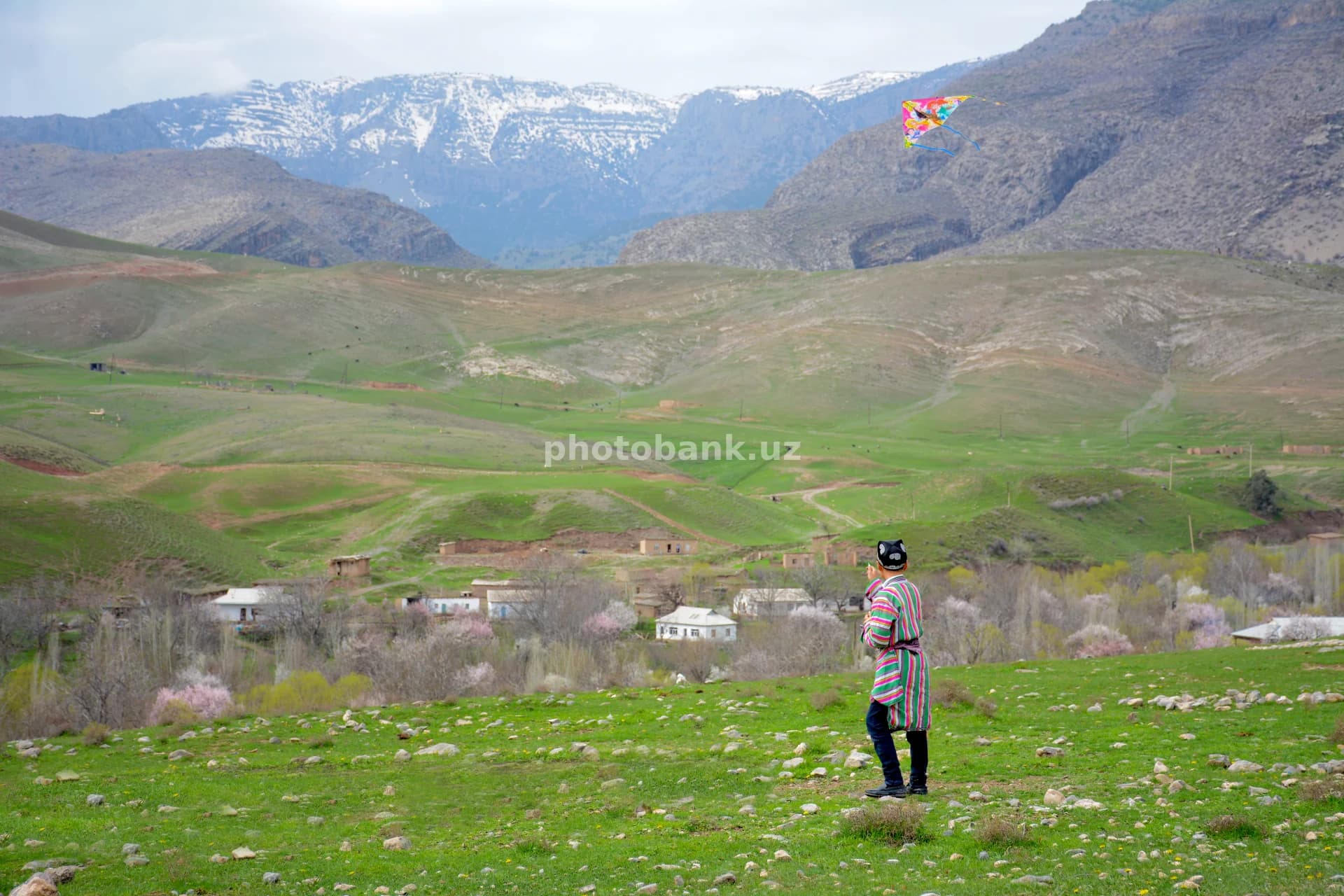 Boy flying kite in mountain village