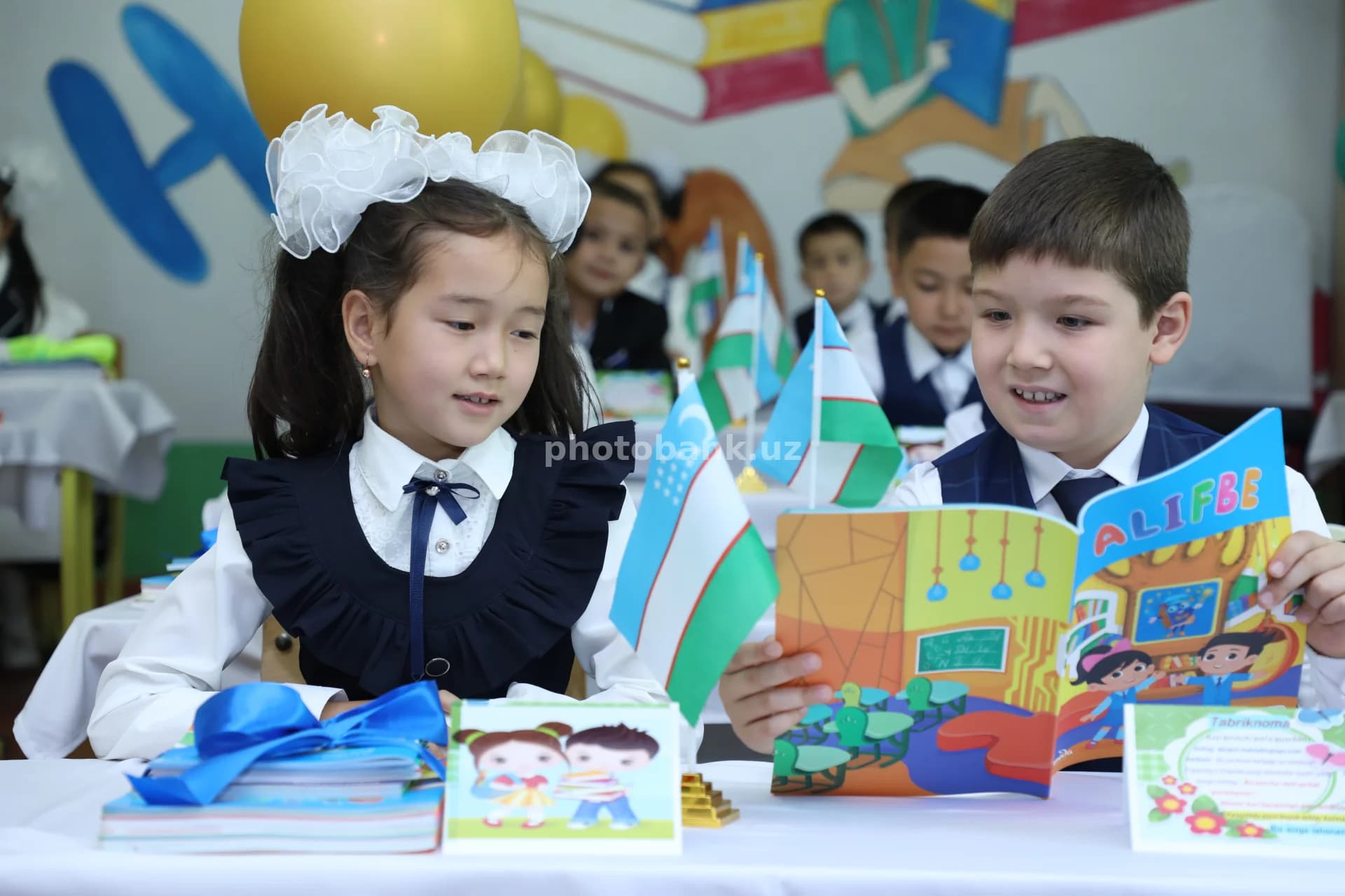 Primary school students reading Alifbe book