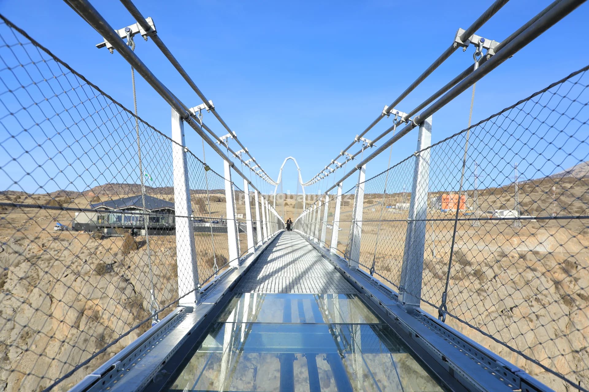 Glass suspension bridge over mountain canyon
