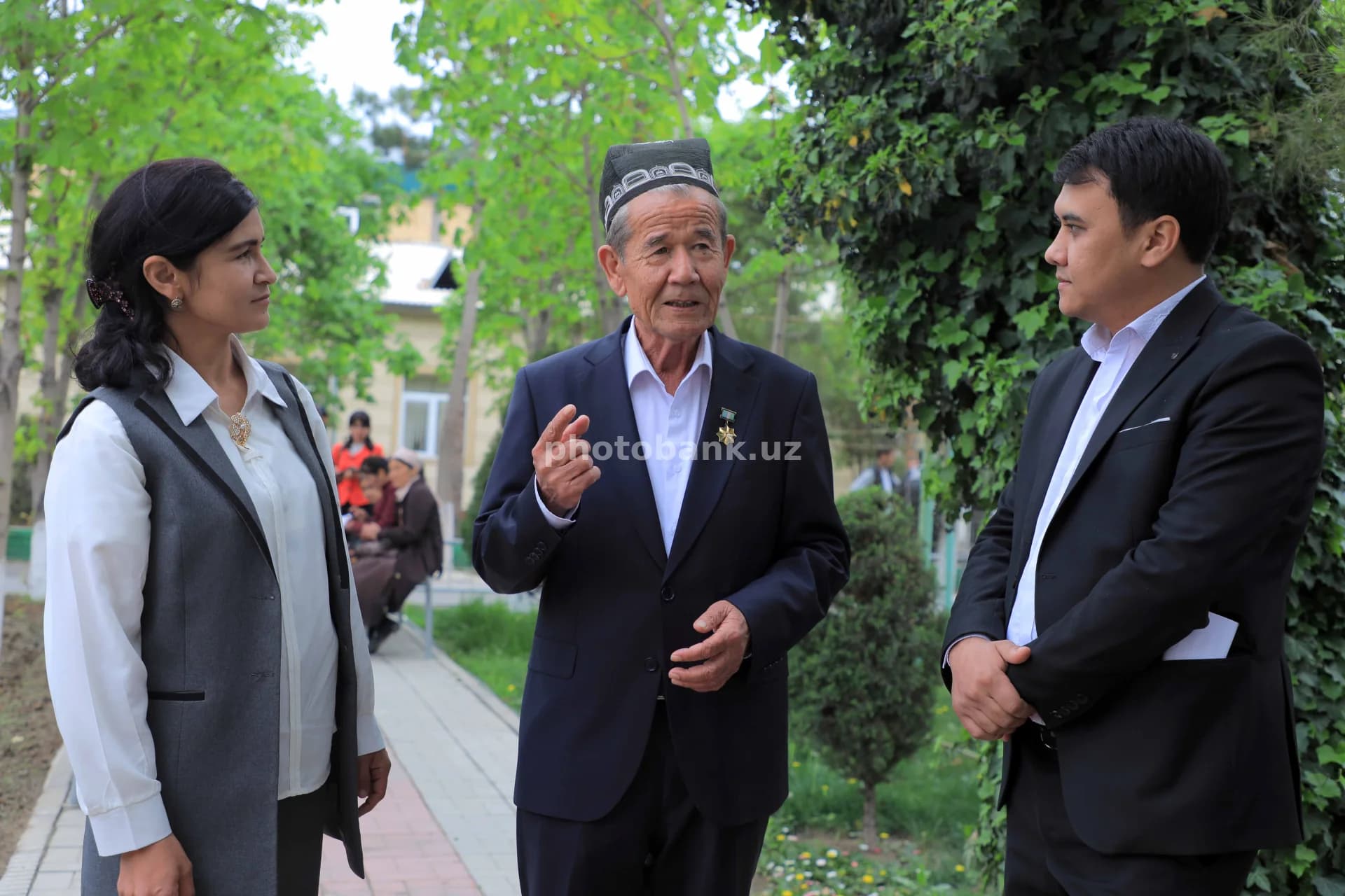 Keksa kishi tashrif buyuruvchilar bilan suhbatlashmoqda