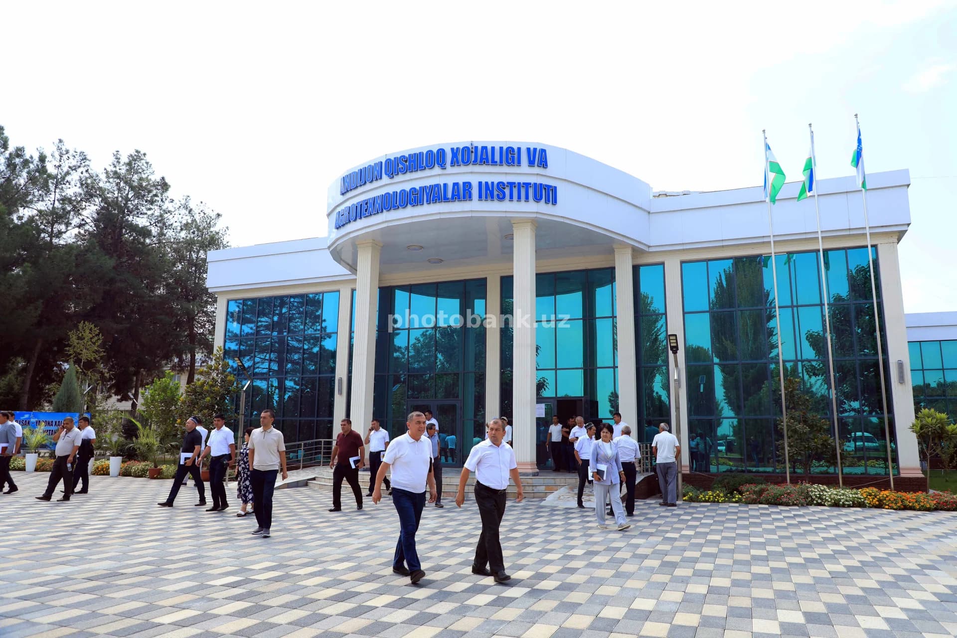 Odamlar universitet binosi tashqarisida sayr qilishmoqda