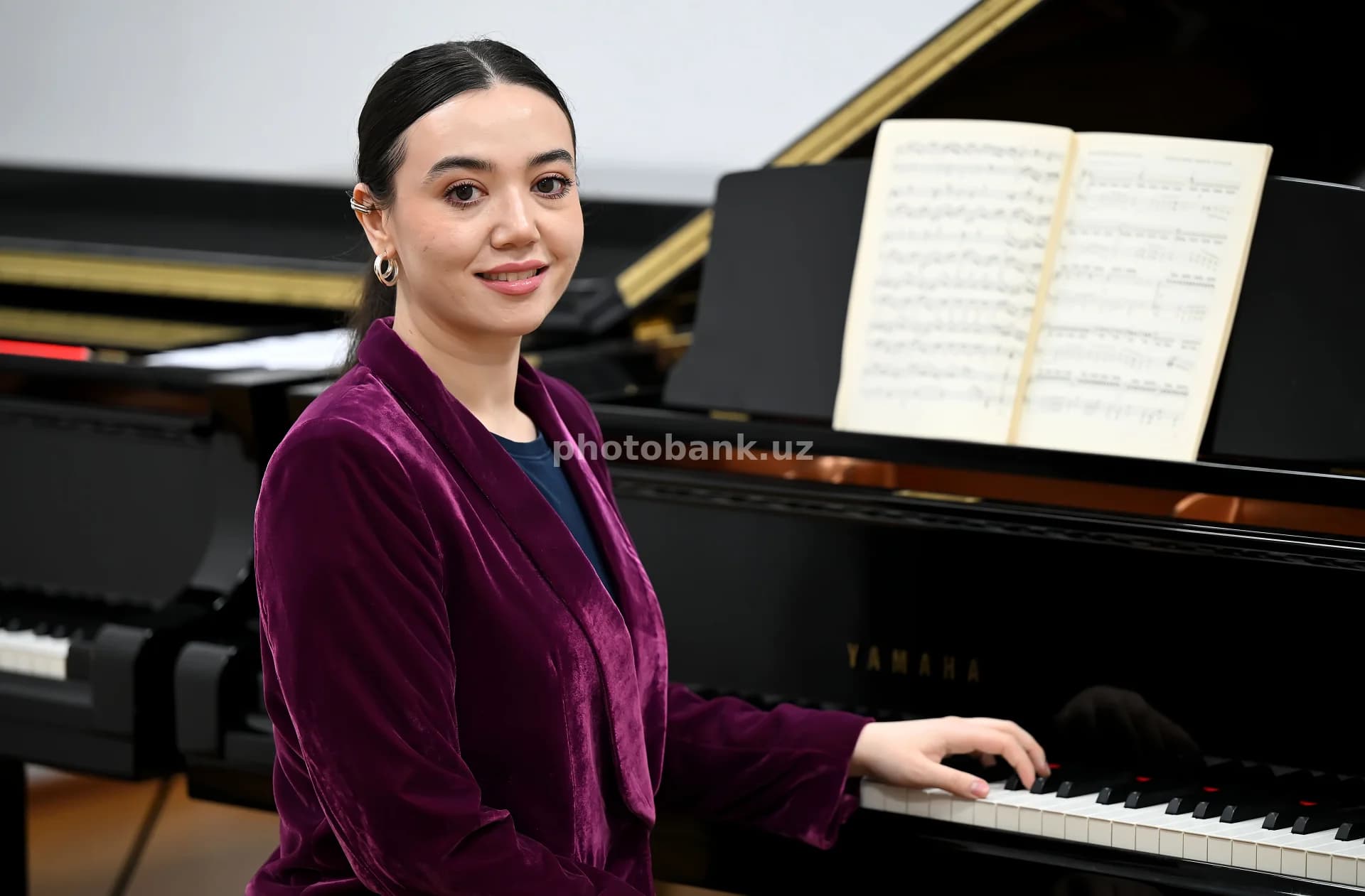Yosh ayol grand pianino chalmoqda
