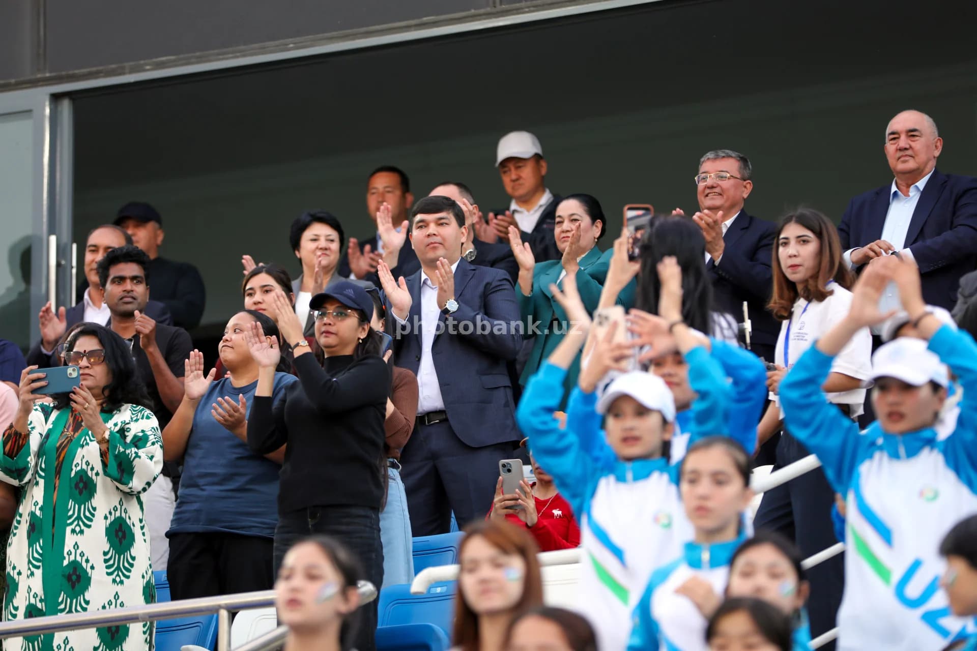 Stadiondagi tadbirda tomoshabinlar qarsak chalmoqda