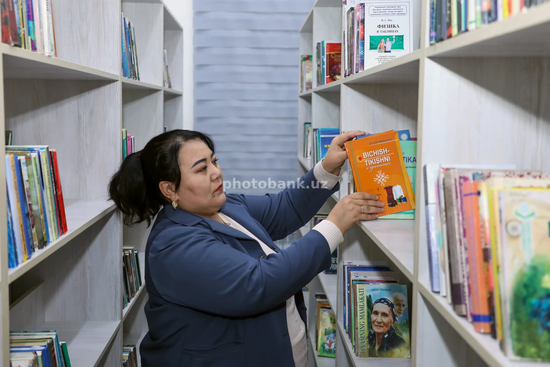 Librarian organizing books on shelves