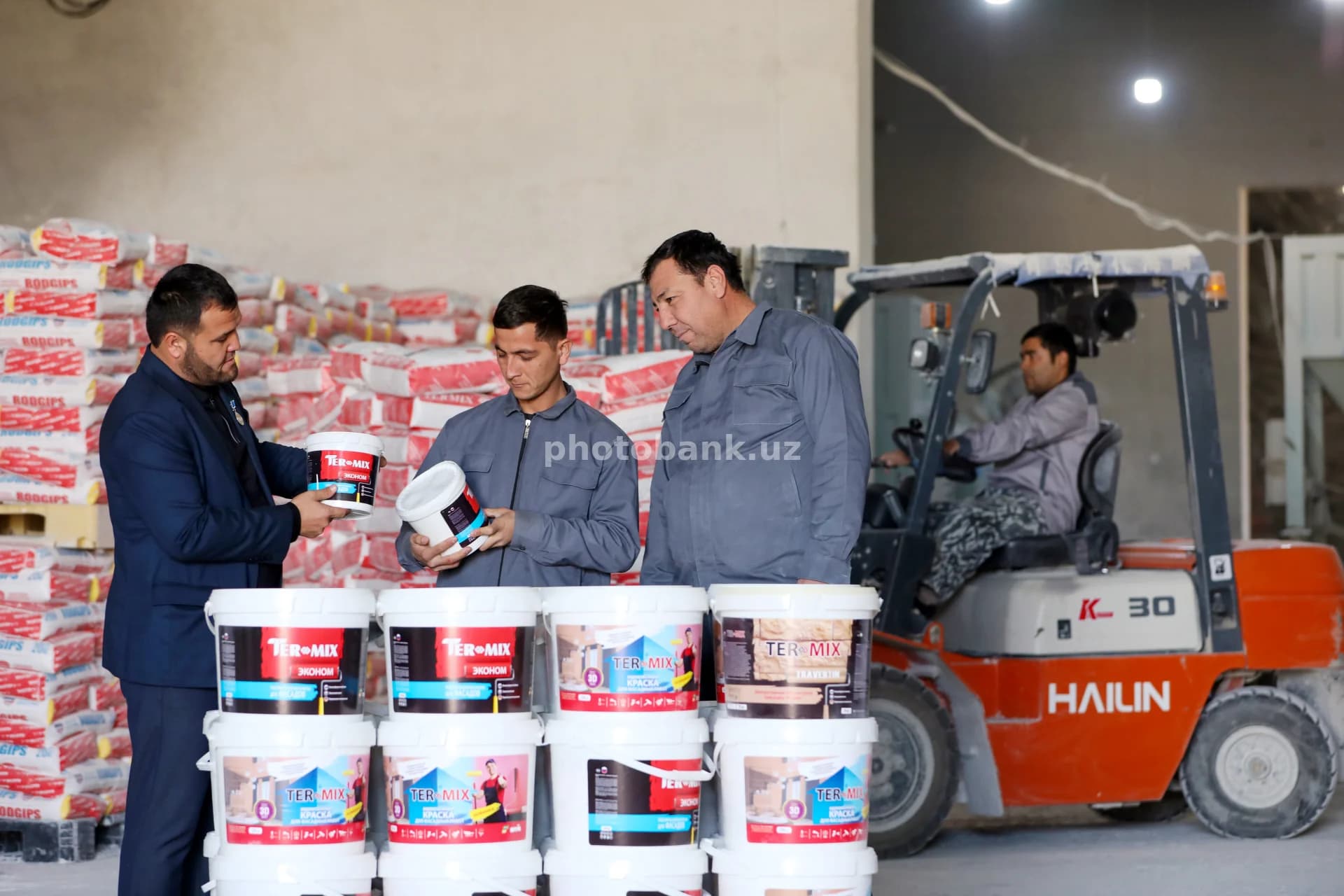 Workers inspecting paint bucket quality
