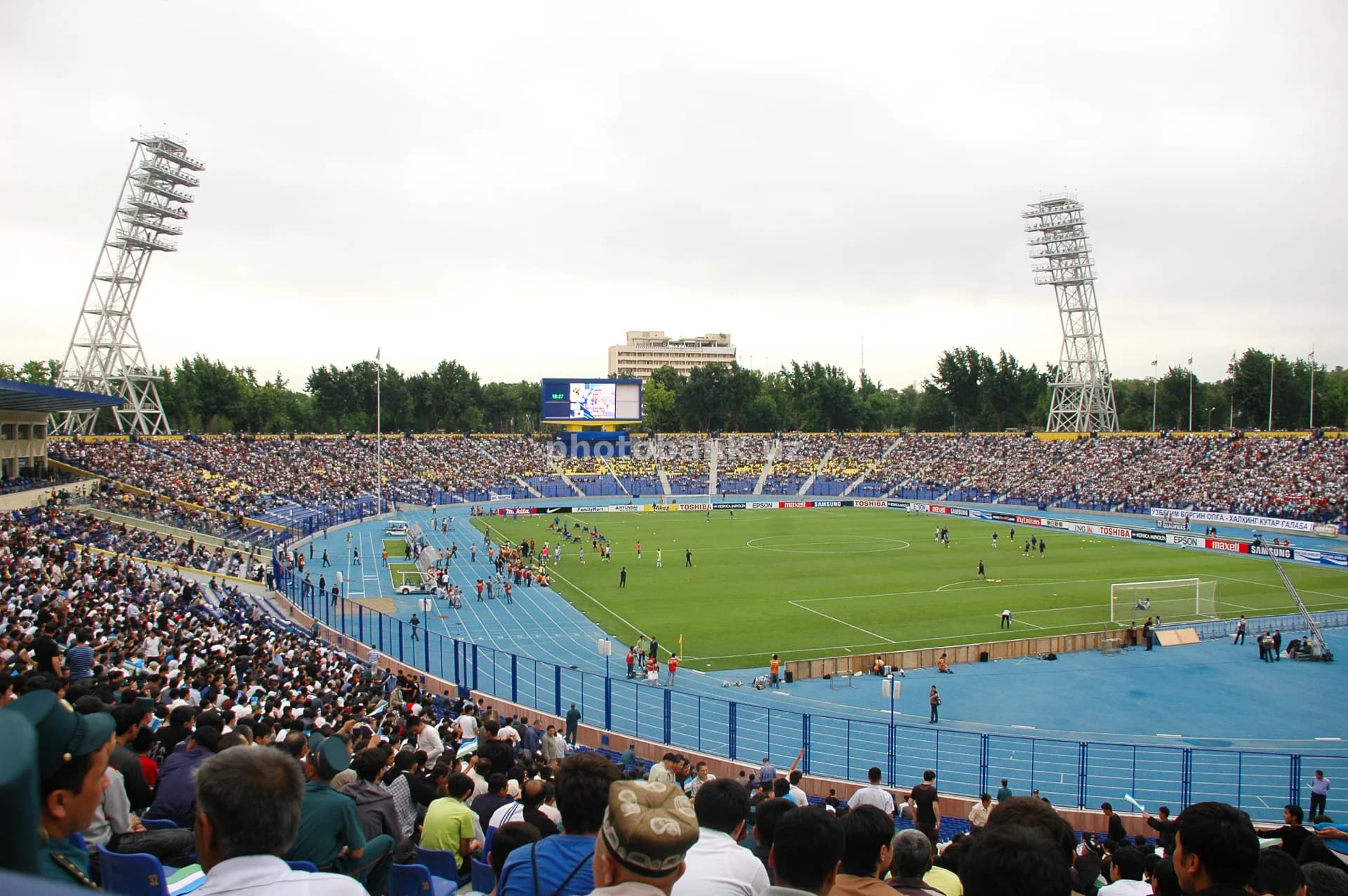 Tomoshabinlar katta ochiq stadionni toʻldiradi.