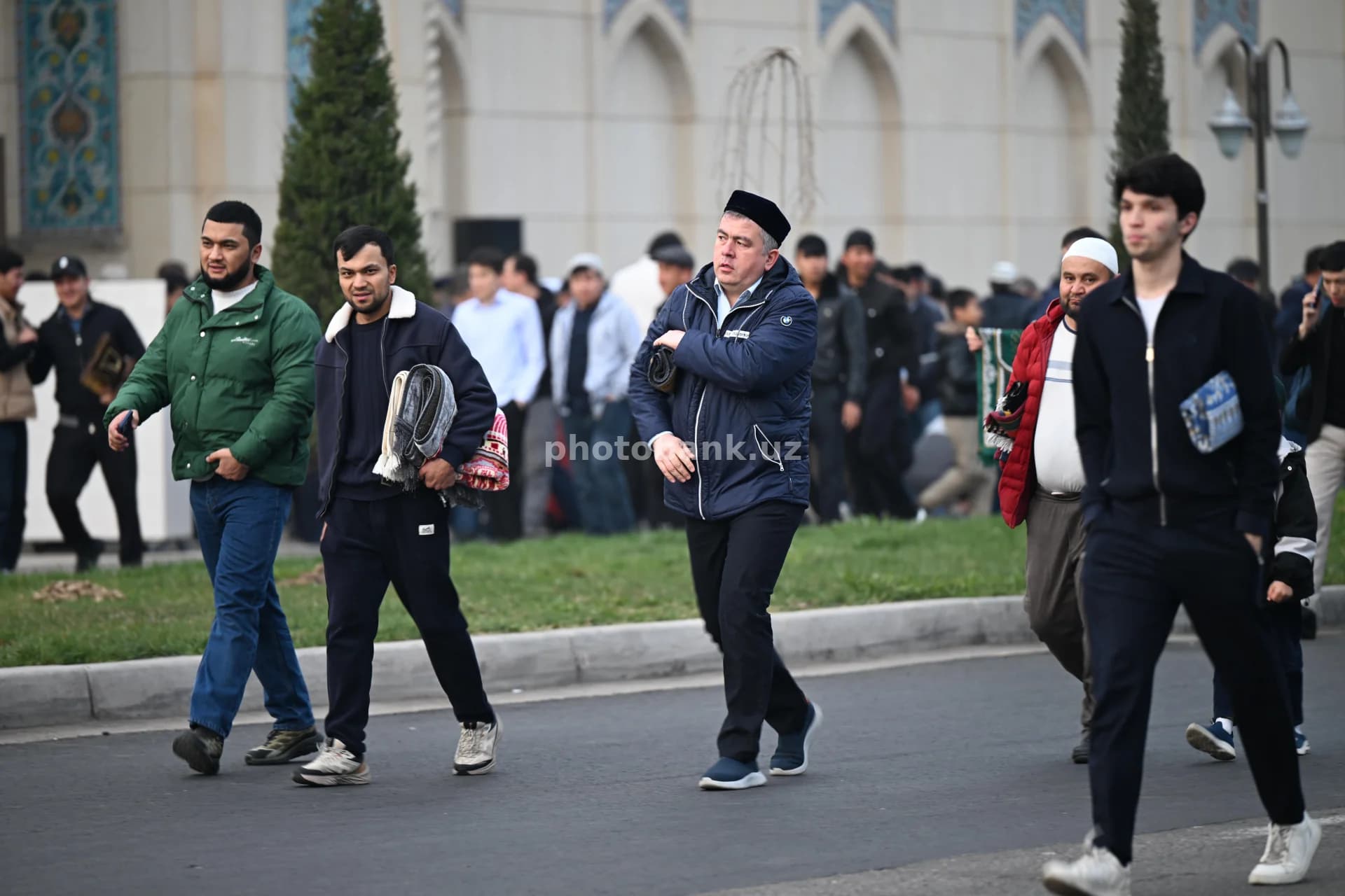 shahar masjidi yonida sayr qilayotgan erkaklar
