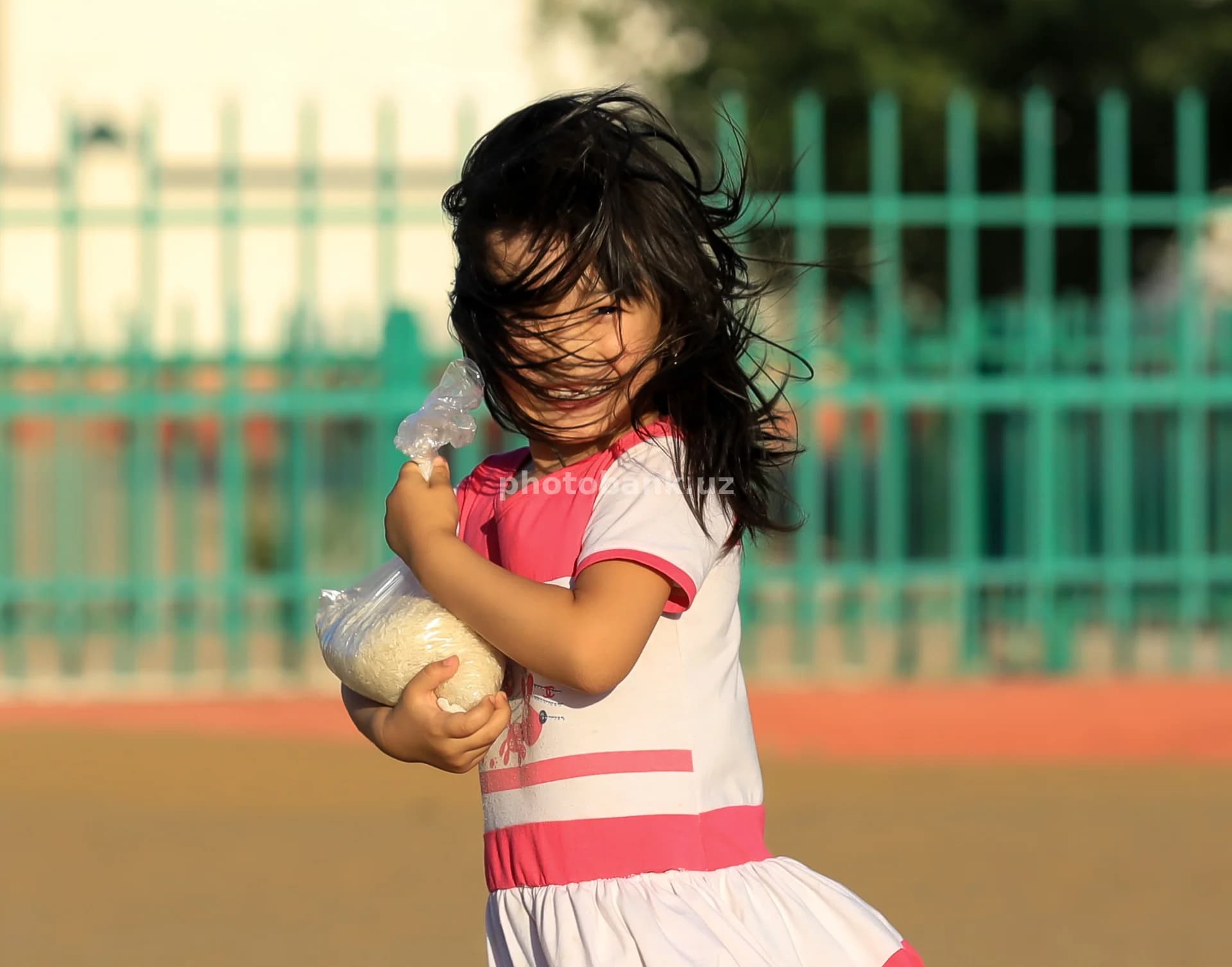 Young girl carries rice bag