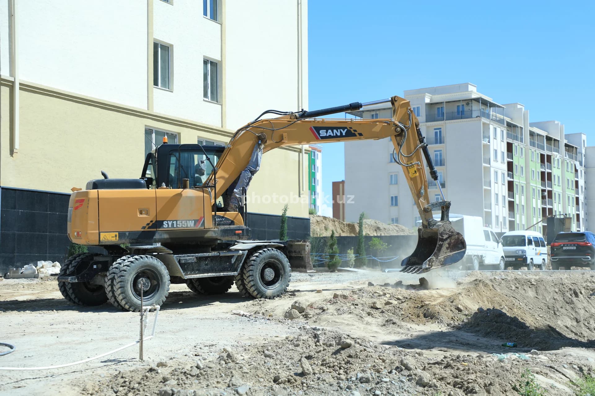 Shahar tuprogʻini qazayotgan sariq ekskavator