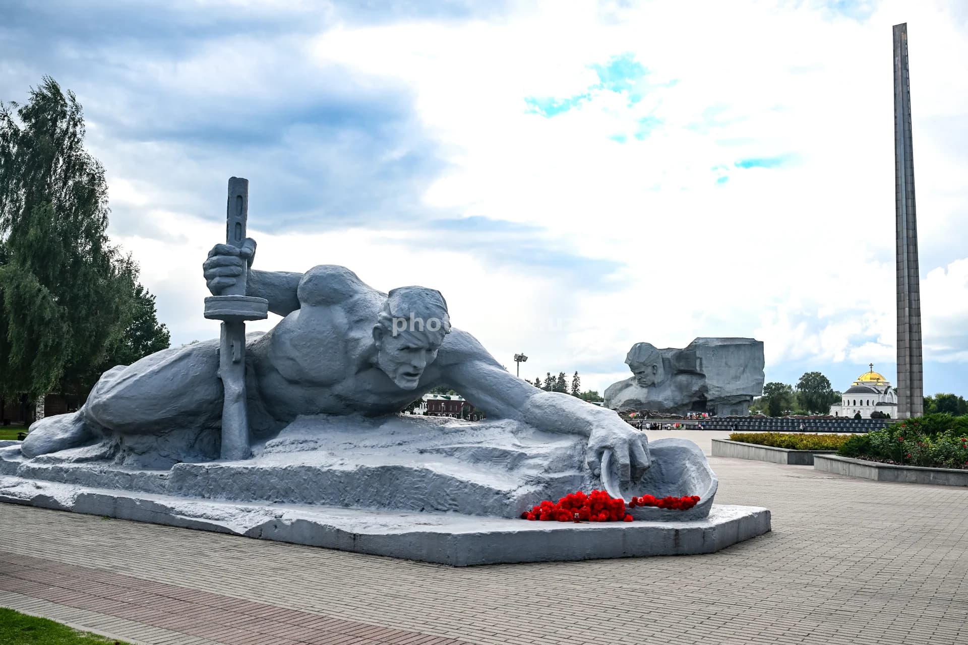 Red flowers lie before monument