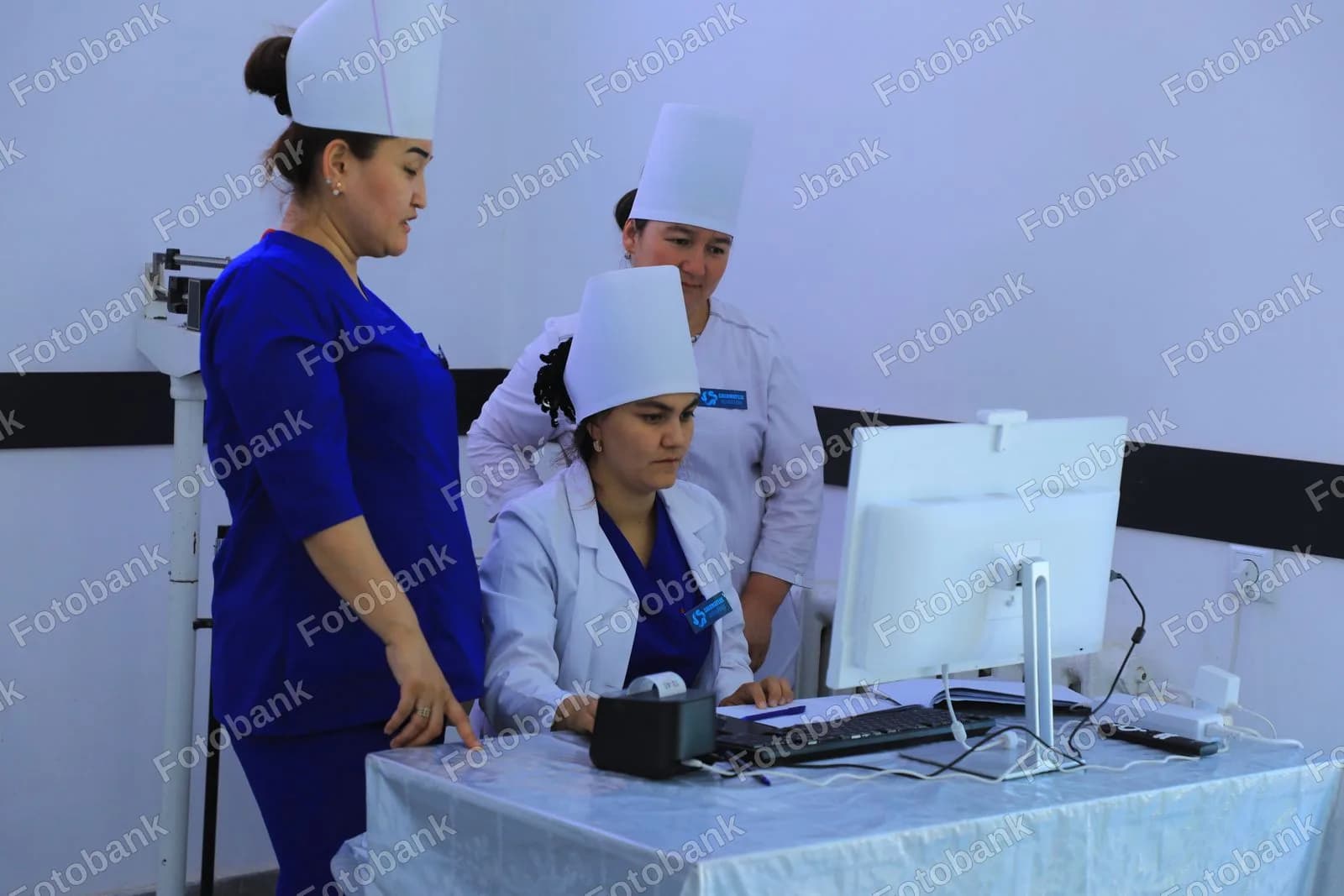 Bemor maʼlumotlarini koʻrib chiqayotgan tibbiyot xodimlari