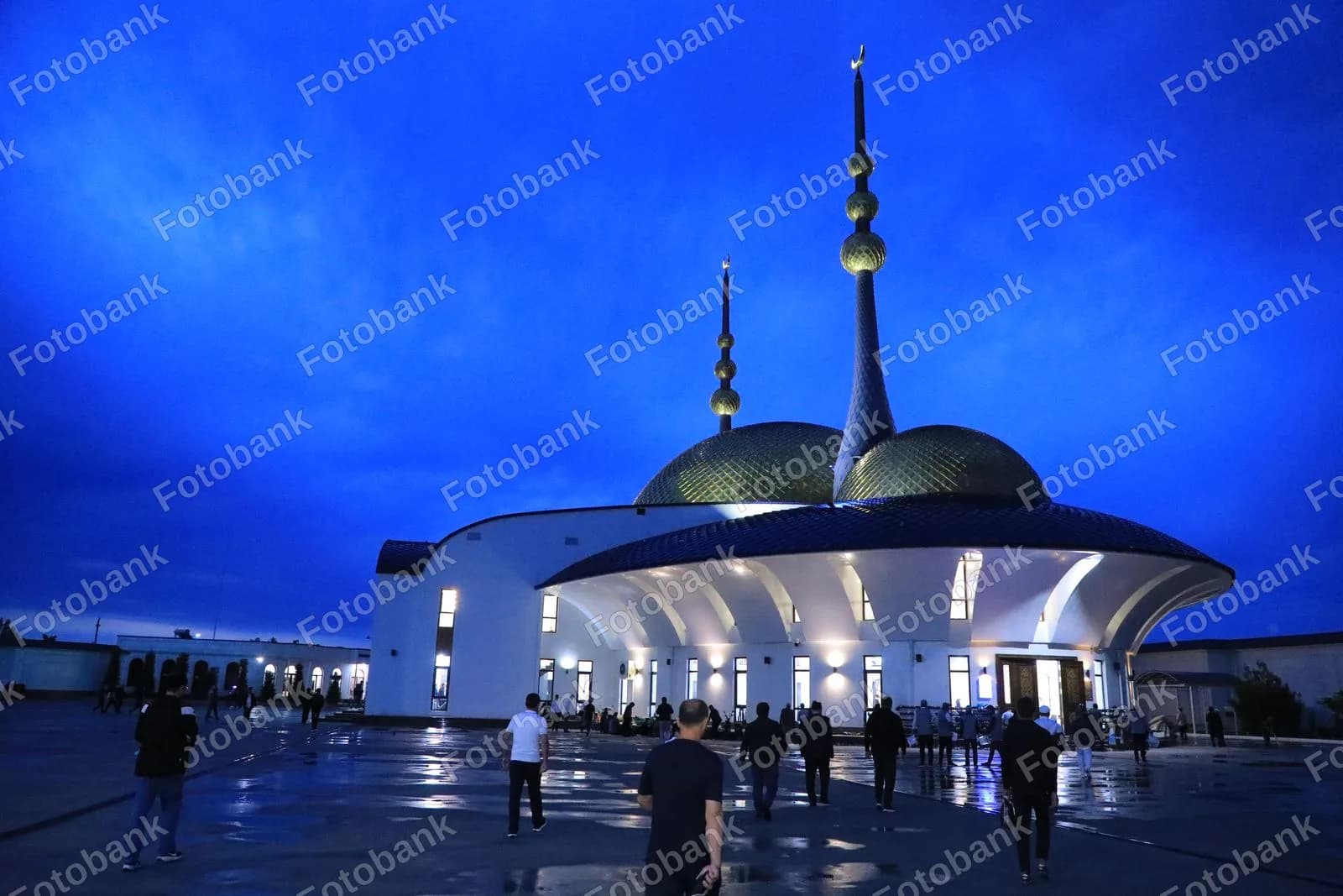Odamlar yoritilgan masjid tomon yurishmoqda