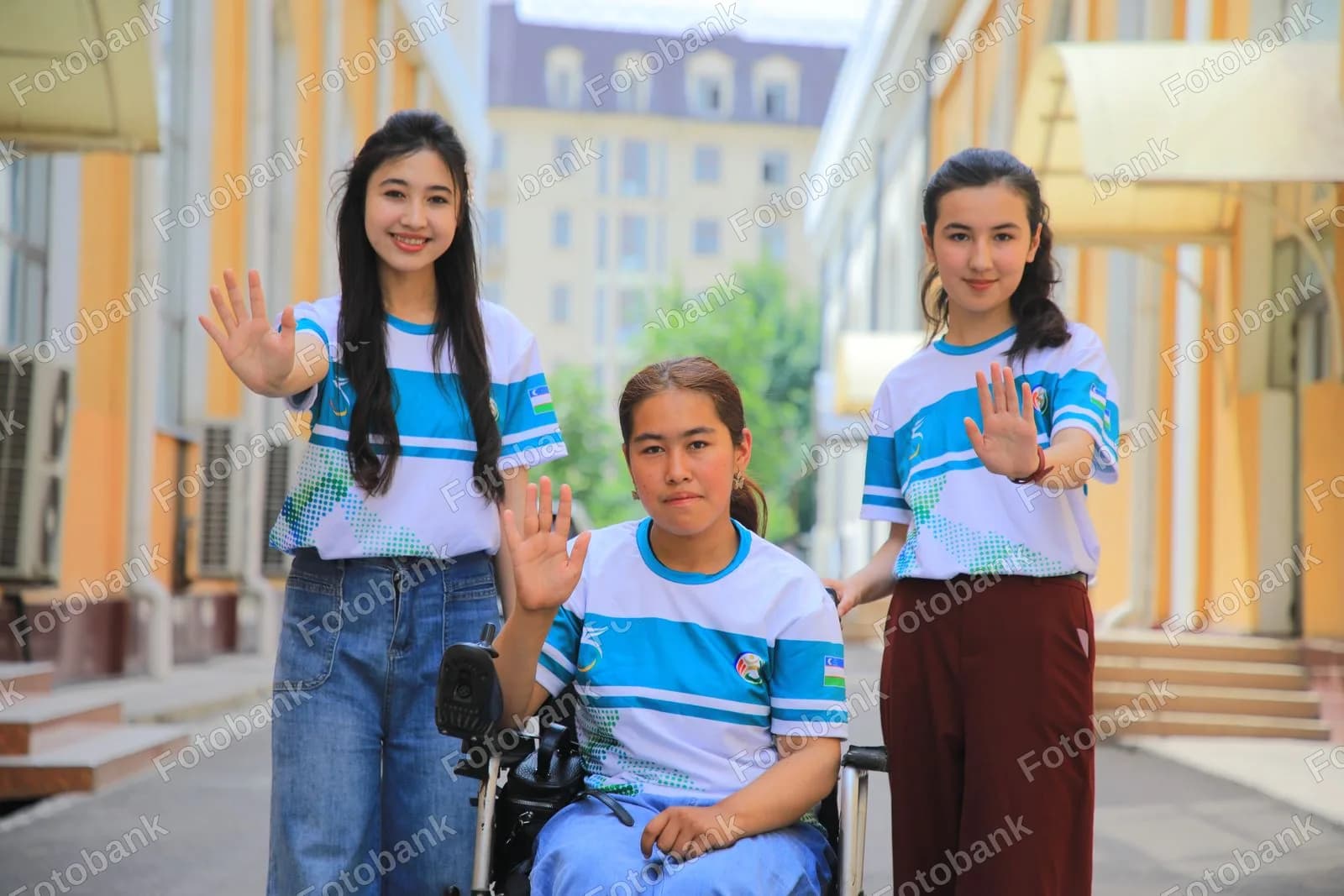 Uch nafar yosh ayol qoʻl silkitmoqda