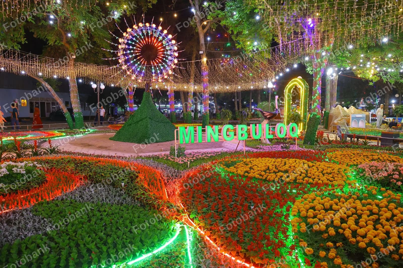 Yoritilgan park hududiga tashrif buyurgan odamlar