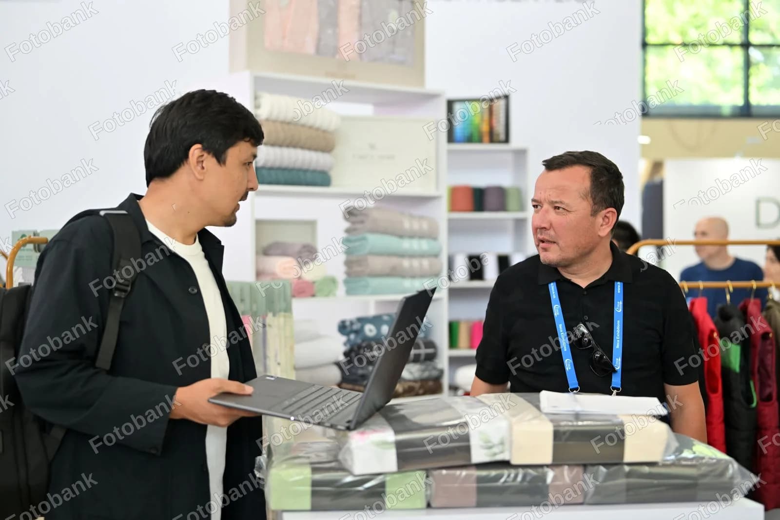 Koʻrgazmada biznesni muhokama qilayotgan erkaklar