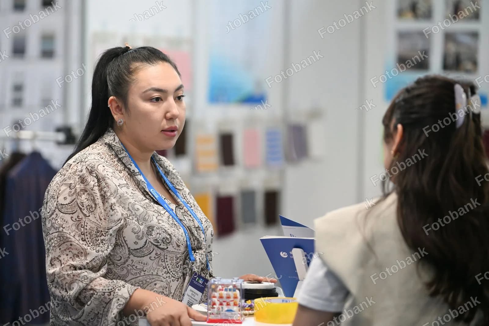 Koʻrgazmada mahsulotlarni muhokama qilayotgan tadbirkor ayol