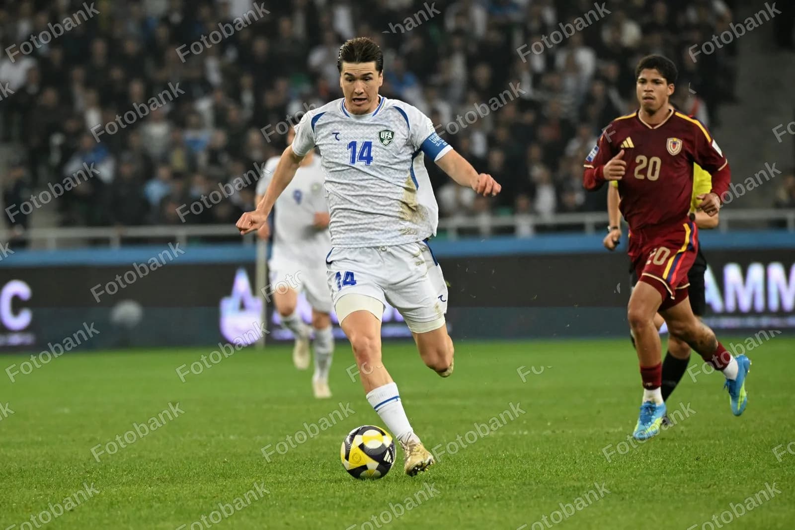Maydon boʻylab dribling qilayotgan futbolchi