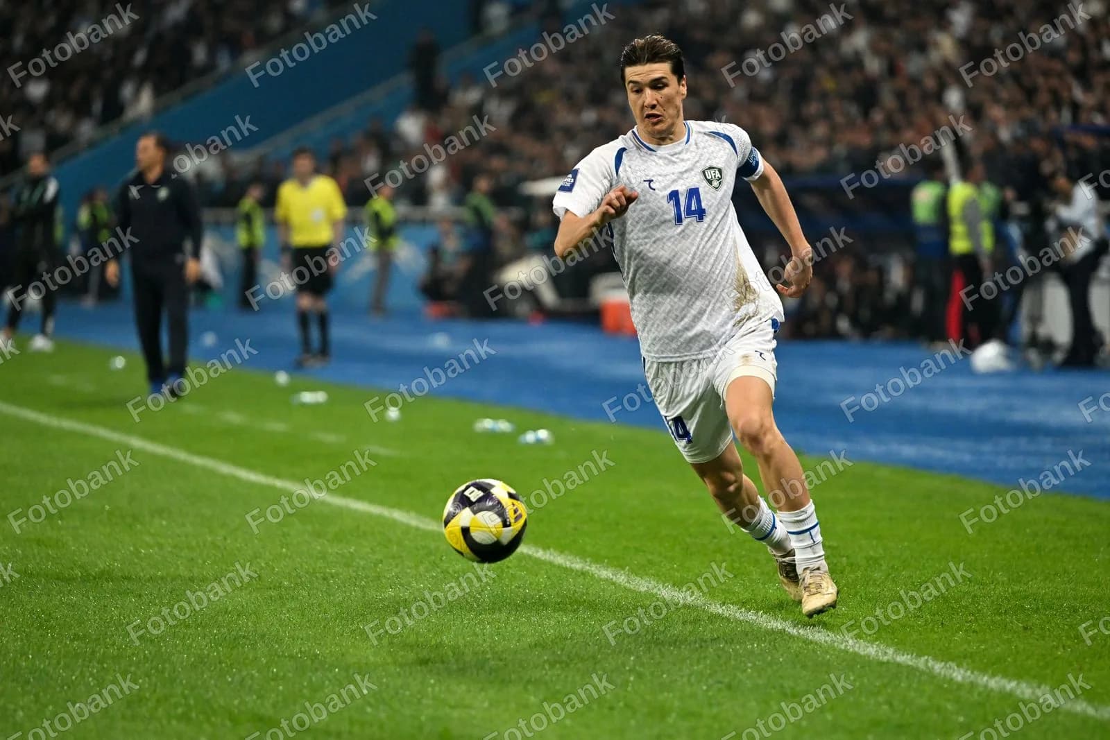 Maydon boʻylab dribling qilayotgan futbolchi