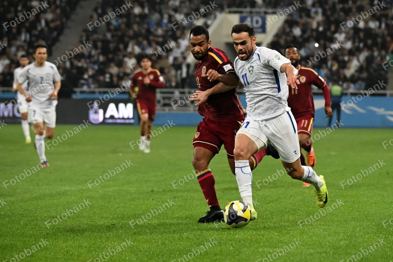 Futbol toʻpi uchun kurashayotgan sportchilar