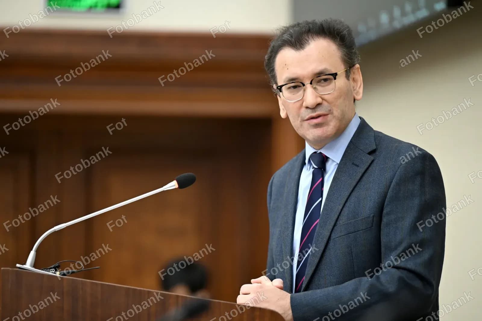 Erkak yogʻoch minbarda nutq soʻzlamoqda