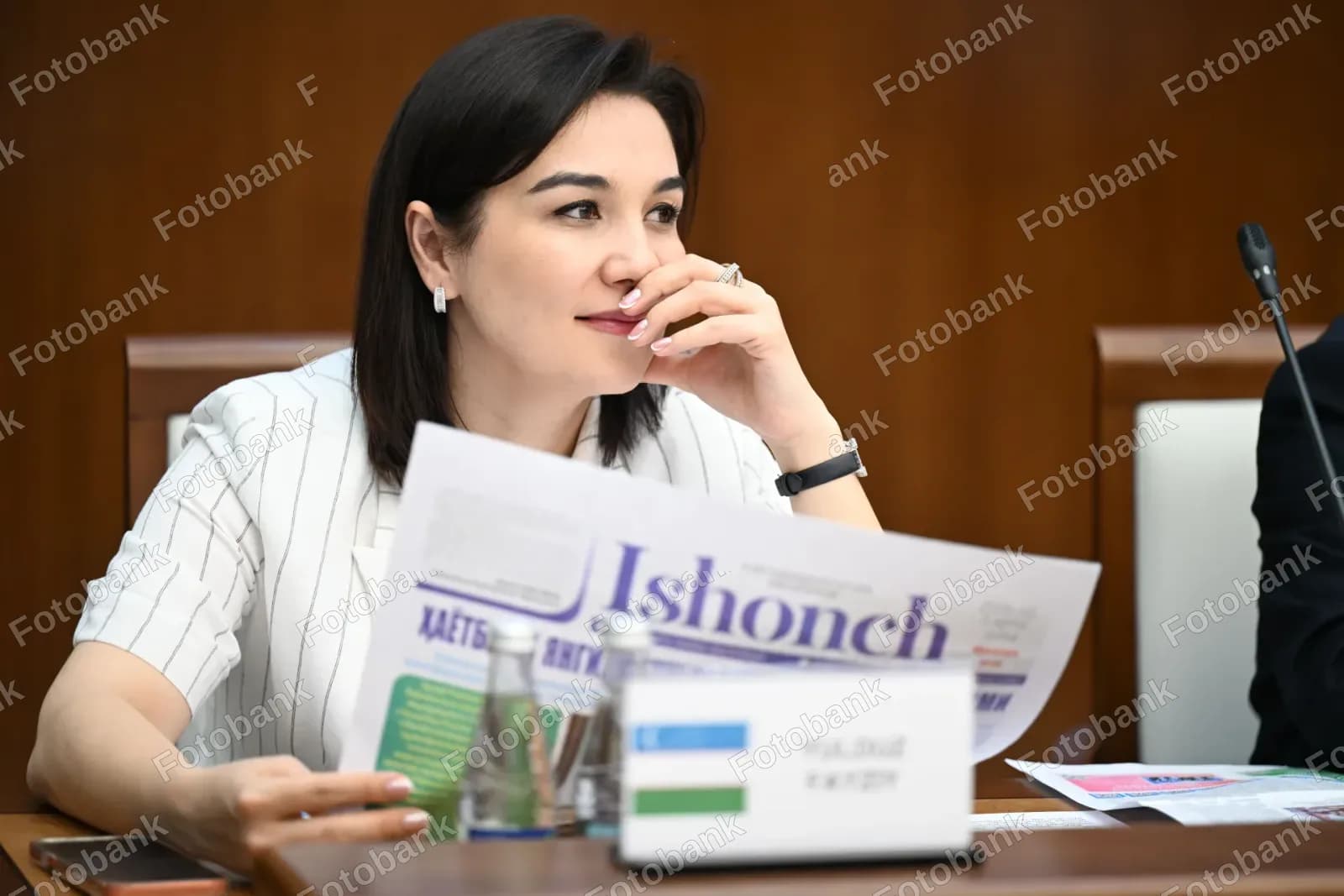 Majlisda gazeta oʻqiyotgan ayol
