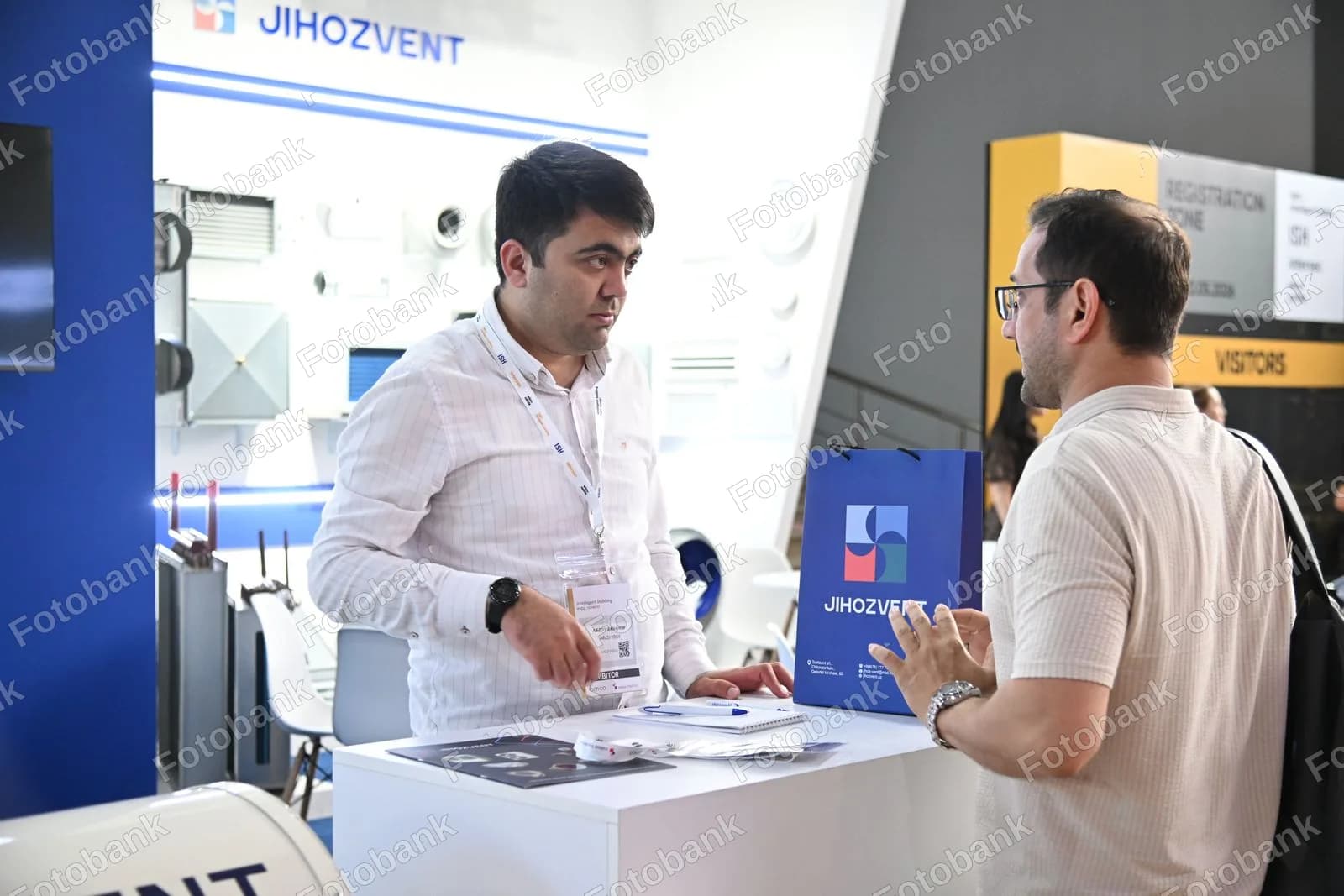 Exhibitor discusses products with visitor