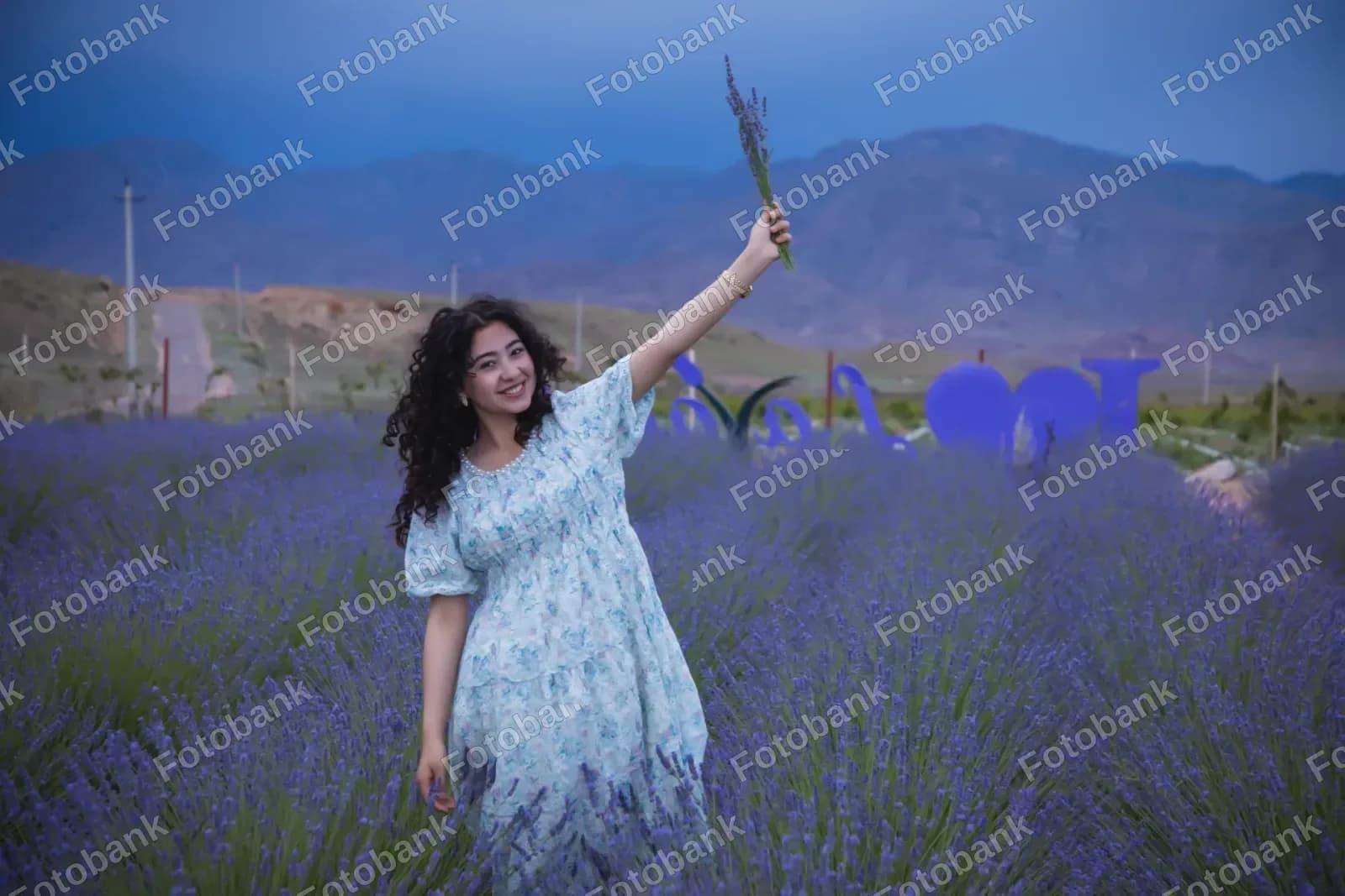 Lavanda gullarini ushlab turgan yosh ayol