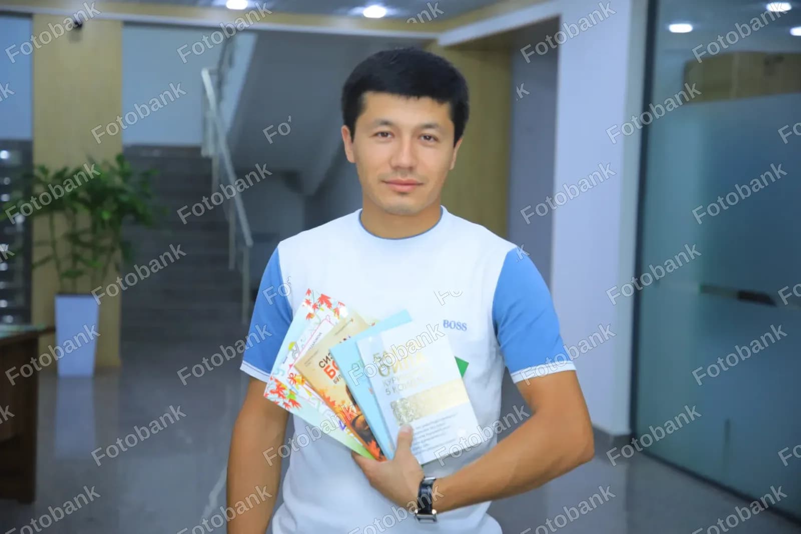 молодой человек, держащий несколько книг