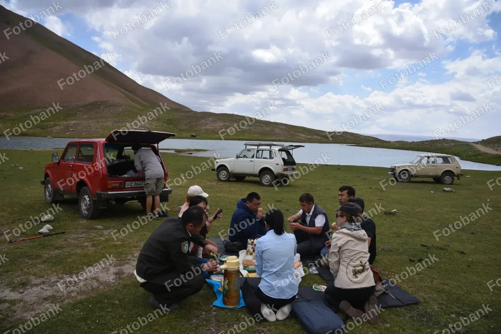 Guruh koʻl yaqinida piknik qilmoqda